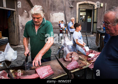 Fischhändler Vorbereitung ein Stück Fisch für einen Client im La Pescheria. Catania, Sizilien, Italien Stockfoto