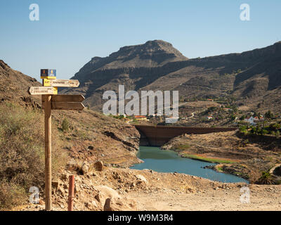 Direktionale zeichen Post mit Blick auf ayaguares Behälter und Dorf, Gran Canaria, Spanien Stockfoto