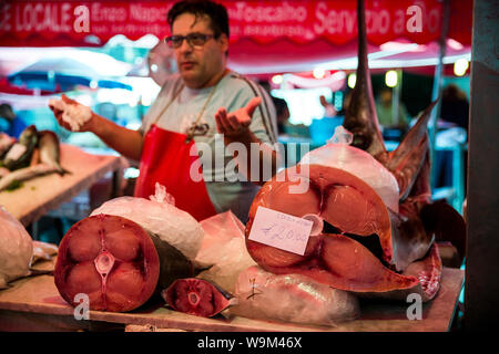 Fischhändler und Stücke von Schwertfisch im La Pescheria. Catania, Sizilien, Italien Stockfoto