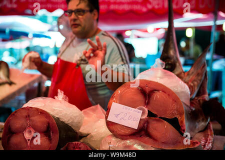 Fischhändler und Stücke von Schwertfisch im La Pescheria. Catania, Sizilien, Italien Stockfoto