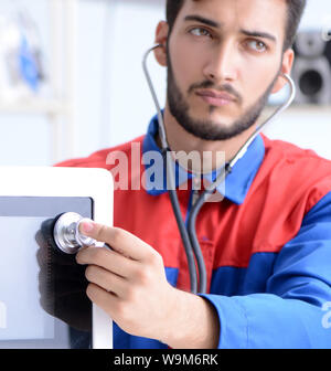 Der junge Handwerker zur Festsetzung und Instandsetzung Mikrowelle Stockfoto