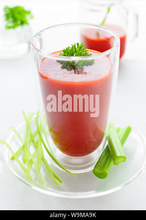 Bio Tomatensaft mit Petersilie und Sellerie, auf weißer Tisch Stockfoto