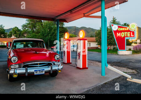 Dämmerung Blick auf 1955 Studebaker President classic car Vor antiken gas Pumpen elektrische Auto Ladegeräte konvertiert geparkt; den Kreis R Motel; Salida Stockfoto