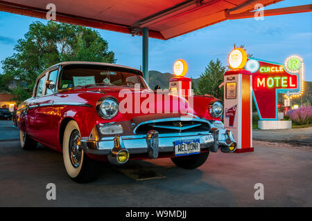 Dämmerung Blick auf 1955 Studebaker President classic car Vor antiken gas Pumpen elektrische Auto Ladegeräte konvertiert geparkt; den Kreis R Motel; Salida Stockfoto