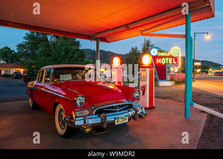 Dämmerung Blick auf 1955 Studebaker President classic car Vor antiken gas Pumpen elektrische Auto Ladegeräte konvertiert geparkt; den Kreis R Motel; Salida Stockfoto