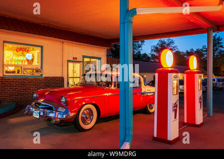 Dämmerung Blick auf 1955 Studebaker President classic car Vor antiken gas Pumpen elektrische Auto Ladegeräte konvertiert geparkt; den Kreis R Motel; Salida Stockfoto