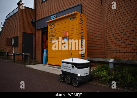 Starship Lieferung Roboter vor einem Amazon Schließfach am Emerson Valley Co-op in Milton Keynes. Die Roboter Lieferung Lebensmittel. Stockfoto