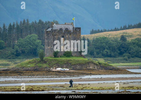 Castle Stalker dargestellt bei Ebbe, der mittelalterliche Turm Haus liegt auf einer kleinen Insel an der Mündung des Loch Laich, Argyll, Schottland gebaut. Stockfoto