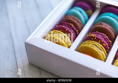 Makronen cookies alle Arten von Farben. Makronen in Feld auf Holz- Hintergrund. Stockfoto