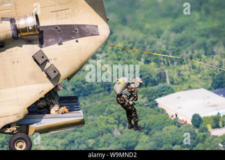 Soldat Sprung aus einem Chinook bei 2019 Leapfest, einer internationalen statische Linie Fallschirm Training und Wettbewerb, bewirtet durch RI Natl. Guard. Stockfoto