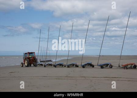 Eine Tractor Pulling 9 verknüpft sand Yachten, ohne Segel, auf den Strand in Vorbereitung für einen Wettbewerb Stockfoto