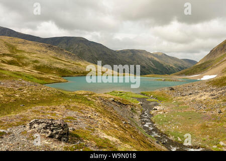 Ein Schnee Gletscherbach fließt in einen Tarn in der alpinen von Palmer Creek Valley in Southcentral Alaska. Stockfoto