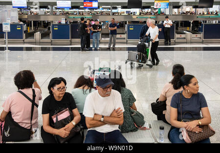 Passagiere gesehen an der Abflughalle des Flughafens warten. Der Betrieb des Hong Kong International Airport hat weitgehend normal, da die Airport Authority Lebenslauf erhalten eine einstweilige Verfügung Menschen aus rechtswidrig und vorsätzlich behindert zu unterlassen oder stört, die ordnungsgemäße Nutzung des Flughafens nach einer chaotischen Nacht der Protest in der Demonstranten auf der Beifahrerseite blockiert den Zugang zu den Flugsteigen, wodurch Hunderte Flüge annulliert wird. Stockfoto