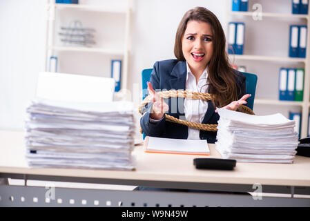 Die junge schöne Mitarbeiter gebunden mit Seil im Büro Stockfoto