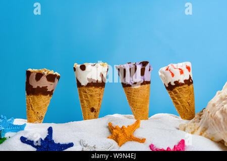 Weißer Sand mit unterschiedlichen Eistüten und Seesterne Konzept der Sommerferien Stockfoto