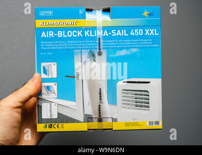 Paris, Frankreich, 28.Juni, 2019: der Mensch Hand auf grauem Hintergrund isoliert das AC die Klimatronic Air-Block Klima Segel 450 XXL die neue Klimaanlage Segel für die Abdichtung von Fenstern und Türen für alle tragbare Klimaanlagen Stockfoto