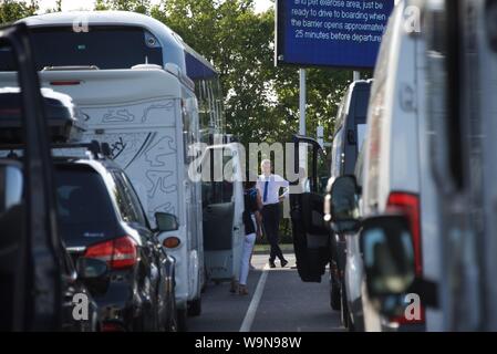 Ein Busfahrer unterhält einige seiner weiblichen Passagiere während der Wartezeit auf den Zügen für Frankreich in der Eurotunnel Folkestone Terminal Stockfoto