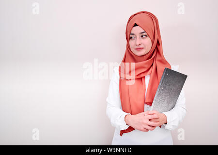 Junge muslimische Mädchen schauen in die Kamera und halten Datei Ordner, zurück in die Schule oder Ausbildung Konzept Foto Stockfoto