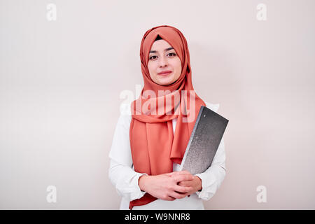 Junge muslimische Mädchen schauen in die Kamera und halten Datei Ordner, zurück in die Schule oder Ausbildung Konzept Foto Stockfoto