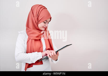 Junge muslimische Mädchen schauen in die Kamera und halten Datei Ordner, zurück in die Schule oder Ausbildung Konzept Foto Stockfoto