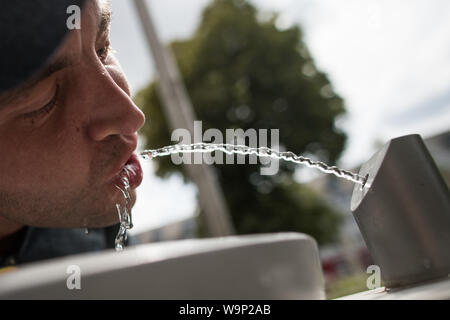 Berlin, Deutschland. 12 Aug, 2019. Patrick stillt seinen Durst mit Wasser gut der Berliner Wasserbetriebe, eine sogenannte "Fill Station'. Es ist nahezu überall verfügbar, Kosten kaum etwas und die Qualität stimmt. Aus der Sicht des Umweltministers, Leitungswasser ist das Mittel der Wahl gegen Durst - auch mit Blick auf den Klimaschutz. (Auf dpa' für Klima und Umwelt: Die Bundesregierung fördert Leitungswasser als Durstlöscher 'Credit): Jörg Carstensen/dpa/Alamy leben Nachrichten Stockfoto