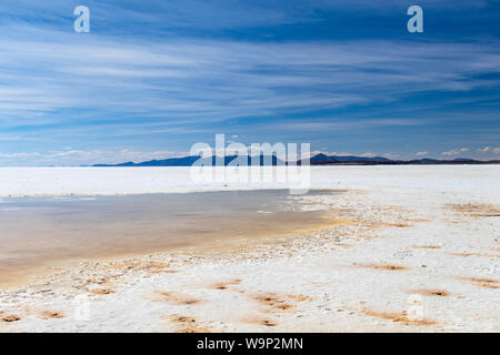 Landschaft von unglaublich weißen Salzsee Salar de Uyuni, inmitten der Anden im Südwesten von Bolivien, dem größten Salzsee Szene der Welt mit blauem Himmel in Sunn Stockfoto