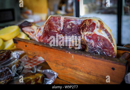 Ganzen Schinken mit Knochen Bein des montenegrinischen Njeguski prsut Schinken ähnlich wie Schinken und geschnittenes verpacktes Fleisch auf dem Markt in Kotor, Montenegro Stockfoto