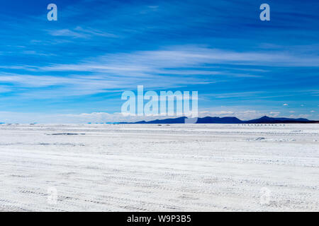 Landschaft von unglaublich weißen Salzsee Salar de Uyuni, inmitten der Anden im Südwesten von Bolivien, dem größten Salzsee Szene der Welt mit blauem Himmel in Sunn Stockfoto