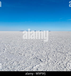 Landschaft von unglaublich weißen Salzsee Salar de Uyuni, inmitten der Anden im Südwesten von Bolivien, dem größten Salzsee Szene der Welt mit blauem Himmel in Sunn Stockfoto