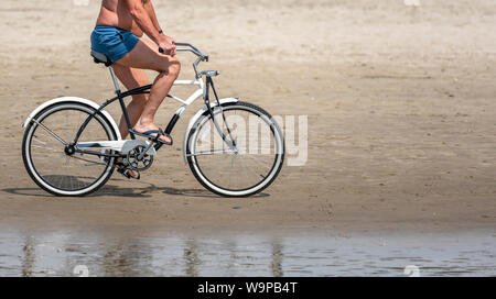 Man Radfahrer Pedale ein Fahrrad und Fahrten entlang des Pazifischen Ozeans, Lieber, einem aktiven gesunden Lebensstil und eine alternative und umweltfreundliche Art der transp Stockfoto