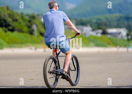 Man Radfahrer Pedale ein Fahrrad und Fahrten entlang des Pazifischen Ozeans, Lieber, einem aktiven gesunden Lebensstil und eine alternative und umweltfreundliche Art der transp Stockfoto