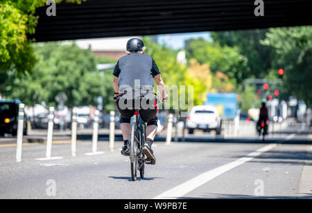 Ein älterer Mann Radfahrer Pedale ein Fahrrad und Fahrten entlang der Portland down town, lieber wie die meisten Portland Bewohner, eine aktive gesunder Lebensstil Stockfoto