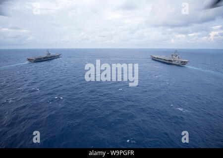 190813-N-YZ 751-1207 ATLANTIK (Aug. 13, 2019) Die Flugzeugträger USS John C Stennis (CVN 74), links, und USS Dwight D. Eisenhower (CVN 69) Durchführung einer ordnance Transfer in den Atlantischen Ozean. Ike ist unterwegs die Durchführung einer Munition onload in Vorbereitung für den künftigen Betrieb. (U.S. Marine Foto von Mass Communication Specialist 1. Klasse Tony D. Curtis) Stockfoto