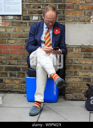 Eine MCC-Mitglied trägt eine Rosette zugunsten der Stiftung Ruth Strauss vor dem Tag zwei der Asche Test Match auf Lord's, London. Stockfoto