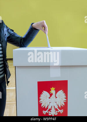 Weibliche Wähler seine Stimme in die Wahlurne während die Wahlen zum polnischen Parlament Stockfoto