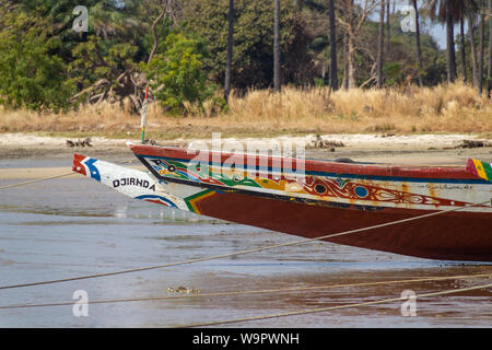 JUFUREH, Gambia - Jan 12, 2014: Das Boot ist bunt und gut gemalt. Die Boote sind selbst gemacht von dem, was die Natur gibt. Lange Bäume werden verwendet Stockfoto