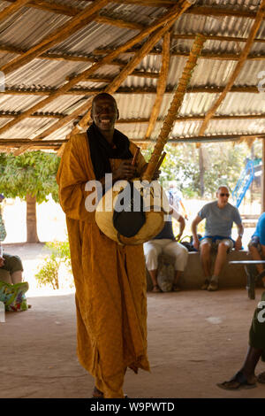 JUFUREH, Gambia - Jan 12, 2014: Die kora ist eine Mandinka Instrument bauen aus einem calebash. Er geht um lächelnd, während Sie das Instrument spielen, Stockfoto