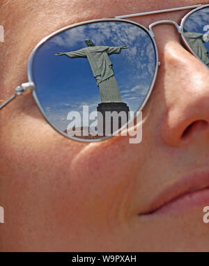 Rio de Janeiro - Juli 12, 2018: Christus der Erlöser in der Sonnenbrille von einem Besucher in Rio de Janeiro nieder. Stockfoto