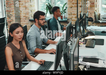 Teamarbeit. Gruppe junger Mitarbeiter arbeiten am Computer während der Sitzung in moderner, offener Raum. Job Konzept. Geschäftsleute. Arbeitsplatz Stockfoto
