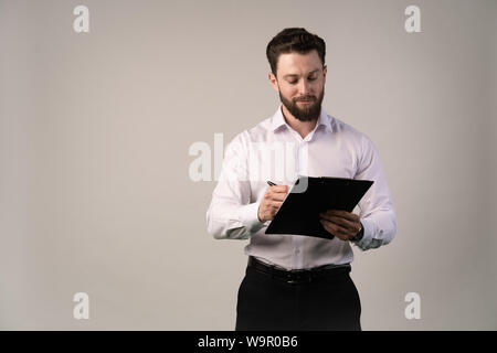 Mittleres Alter, 30-40 s Lächeln, Geschäftsmann, Unterzeichnung des offiziellen Vertrag oder Füllung Business Document mit einem Stift, Arbeiten in modernen Büros, hautnah. Stockfoto