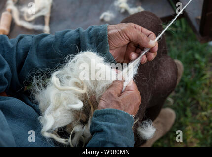 Handwerker mit einem alten Spinnrad wolle in Garn zu drehen. Stockfoto