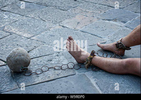 Prisioner mit Kugel und Kette in den Hof des Gefängnisses. Close Up. Konzept der unmenschlichen und entwürdigenden Haftbedingungen. Stockfoto