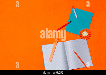 Zurück zu Schule mit Copybooks und Zubehör für Studie über ein helles orange hinterlegt. Kopieren - Raum. Für Text platzieren. Stockfoto