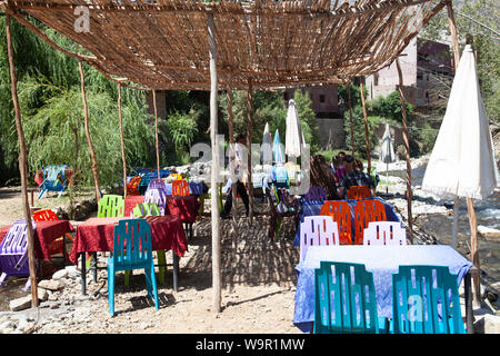 Die Leute sitzen in den Restaurants am Fluss bei Sti Fadma, Ourika Tal in den Atlas, Marokko Stockfoto