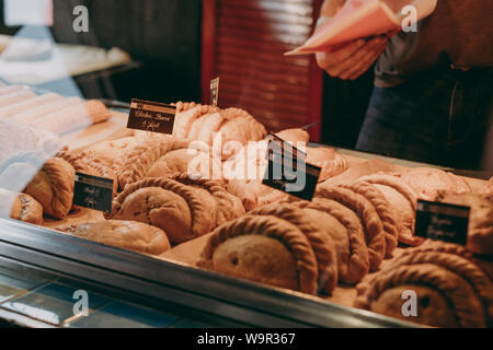 Lymington, Großbritannien - 14 Juli, 2019: Cornish pasties auf Verkauf zu einem Minen eine Pastete shop in Lymington, UK. Cornish pasty ist ein traditionelles britisches Essen particula Stockfoto