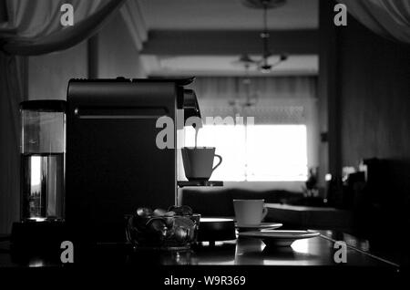 Espressomaschine in Silhouette, Ansicht der Sätze beim Befüllen Kaffeetasse. Stockfoto