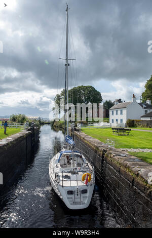 Eine Yacht führt durch eine Schleuse auf dem Crinan Canal an Adrishaig, Argyll, Schottland. Stockfoto