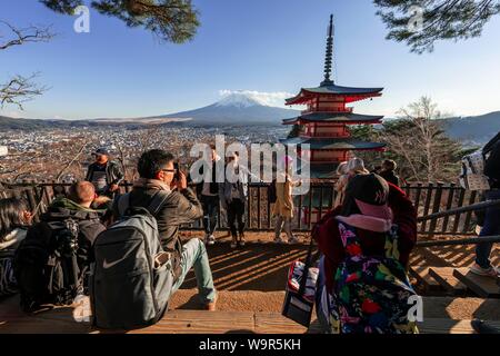 Touristen an einem Aussichtspunkt mit Blick auf die Fünfstöckige Pagode, Chureito Pagode mit Fujiyoshida Stadt und den Berg Fuji Vulkan, Yamanashi Präfektur, Japan Stockfoto