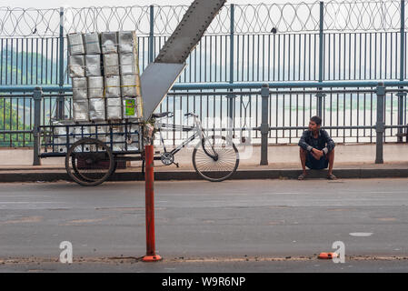 Kolkata, West Bengal/Indien - August 11,2019. Ein nicht identifiziertes Van Rikscha mann Rest der auf der Seite der Howrah Bridge. Stockfoto