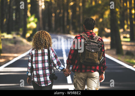 Romantisches Paar ist auf einem Spaziergang in der Mitte der Straße Spaß draußen in einem Bergwald. Trendy hipster Touristische genießen abenteuerliche Vac Stockfoto